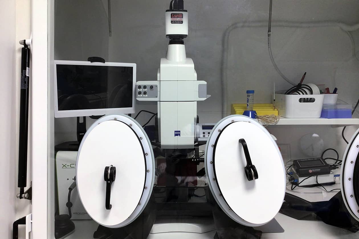 <hr>Macroscope à fluorescence installé dans une boite à gants de confinement pour le tri de moustiques infectés et transgéniques. © L. Ramolu.